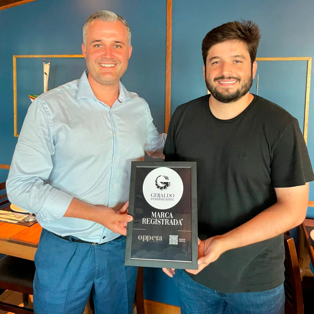 Sócios da Oppera entregando o certificado de marca registrada ao Geraldo Restaurante